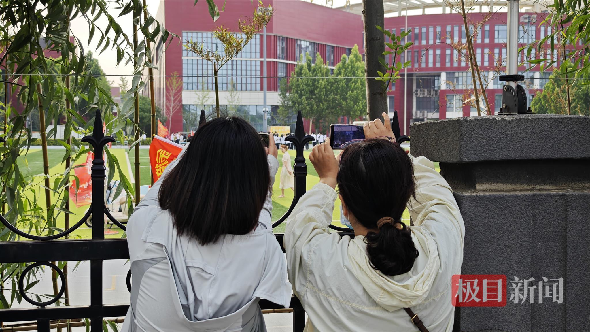 直击衡水中学高考首日：家长隔着栅栏用手机拉长焦拍孩子，有女生赴考前在电话亭与家人通话