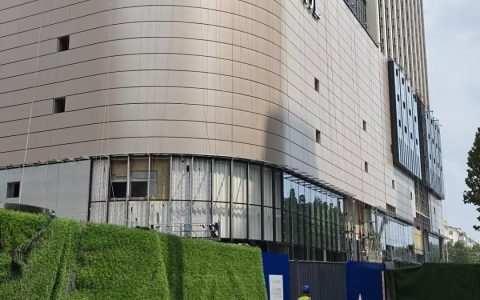 胖东来新店开业仅剩一个月，记者实探：商场已挂上DL标志，玻璃幕墙正陆续安装，店员称新员工或先在老店培训