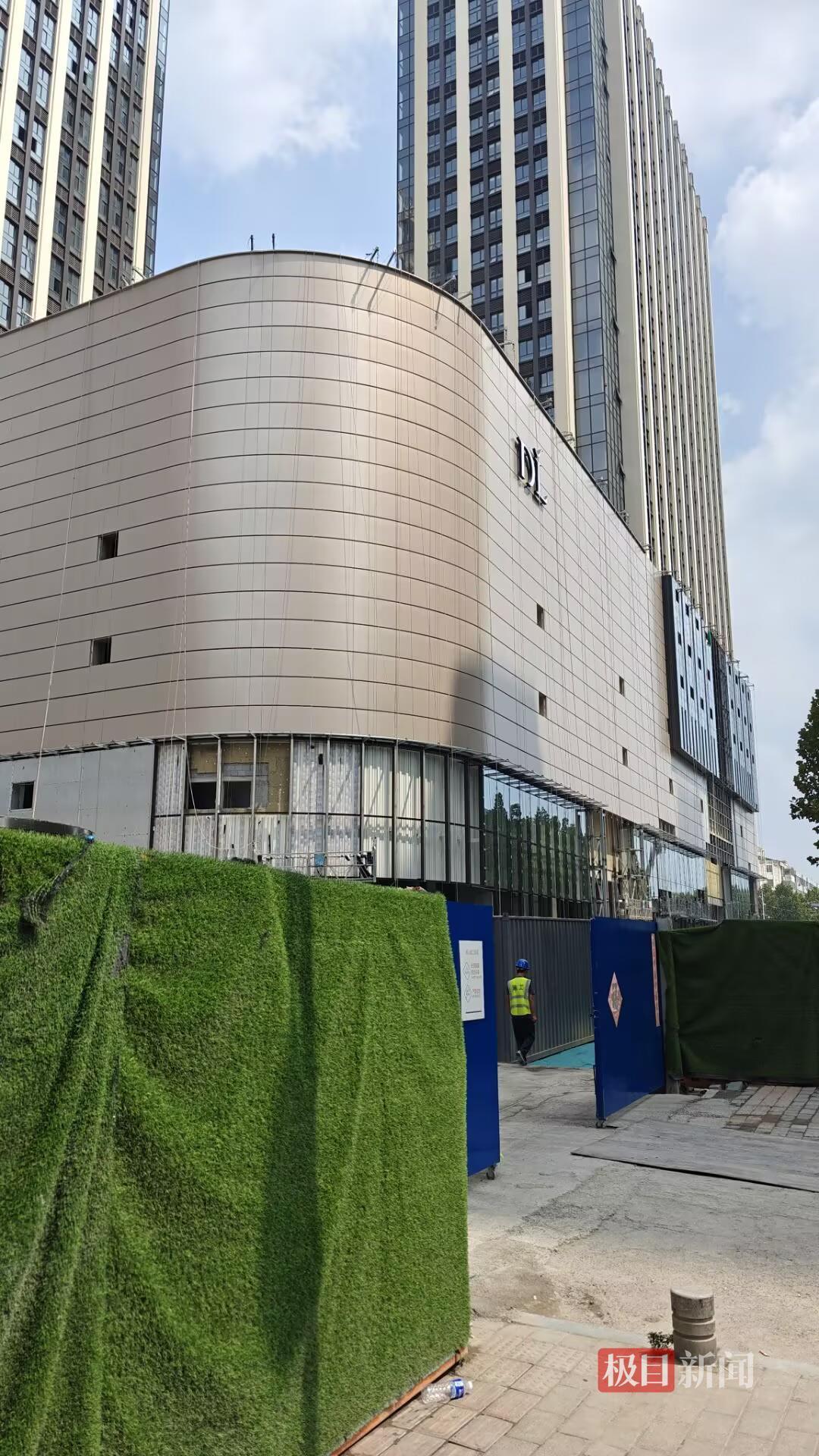 胖东来新店开业仅剩一个月，记者实探：商场已挂上DL标志，玻璃幕墙正陆续安装，店员称新员工或先在老店培训