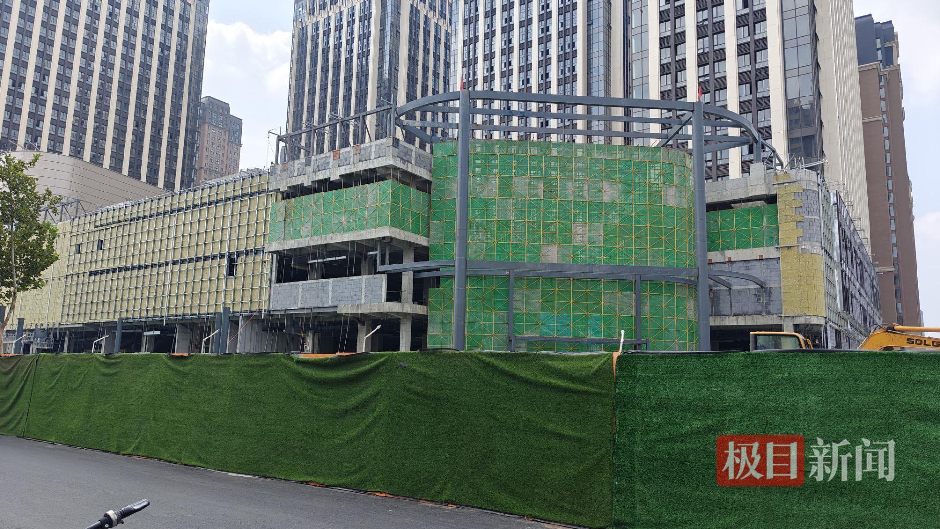 胖东来新店开业仅剩一个月，记者实探：商场已挂上DL标志，玻璃幕墙正陆续安装，店员称新员工或先在老店培训