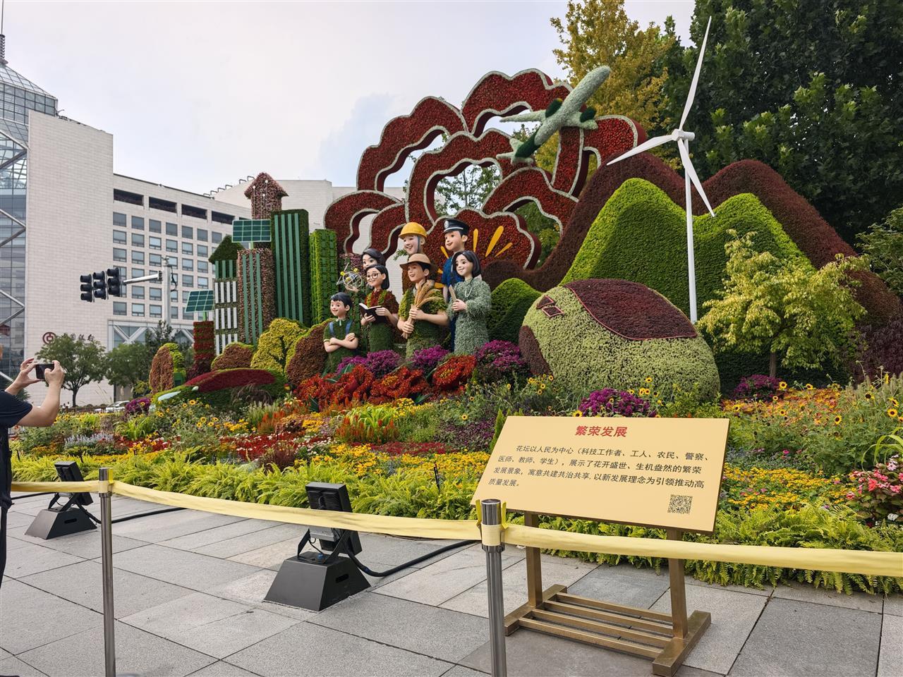 九三阅兵前一日的长安大街：市民乘公交提前感受氛围，小学生姐妹在花坛前敬礼拍照