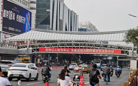 九三阅兵前一日的长安大街：市民乘公交提前感受氛围，小学生姐妹在花坛前敬礼拍照